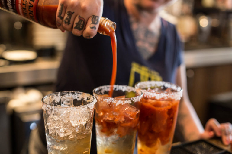 Pairing Cocktails with Signature Dishes at Hash House A Go Go: The Ultimate Las Vegas Dining Guide 1 A bartender making a cocktail and comfort food pairing at Hash House A Go Go West Sahara during an outdoor dining experience in Las Vegas