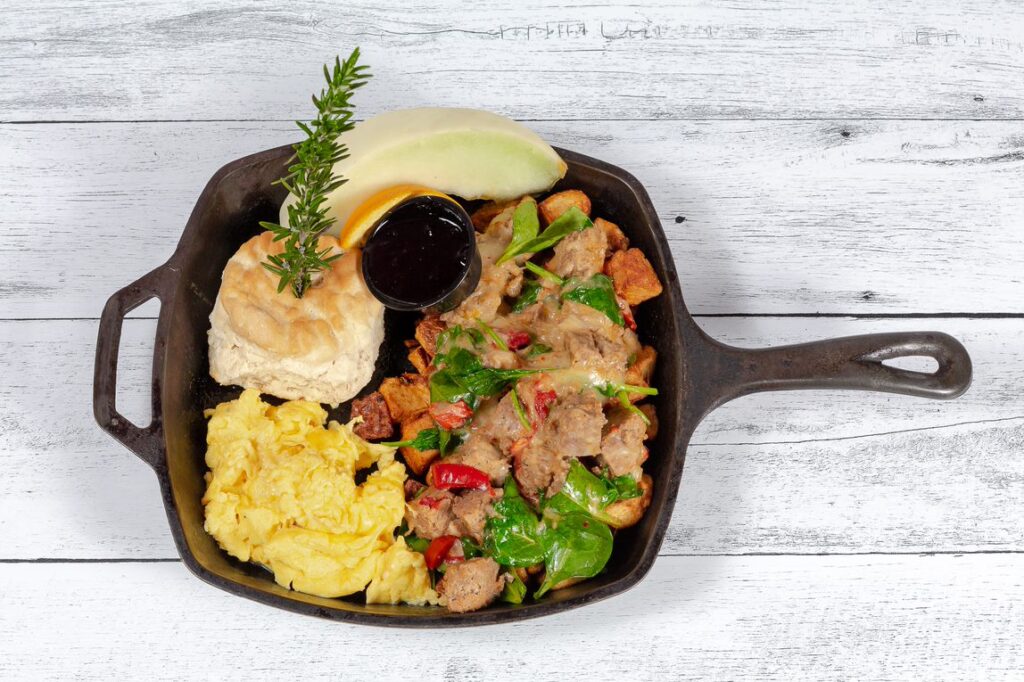 The best breakfast skillet featuring meatloaf hash, scrambled eggs, biscuit, and fresh fruit at Hash House A Go Go in West Sahara, Las Vegas.